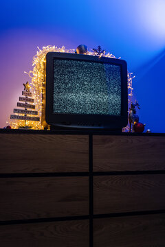 Vintage CRT television with static screen, glowing lights and festive holiday decorations
