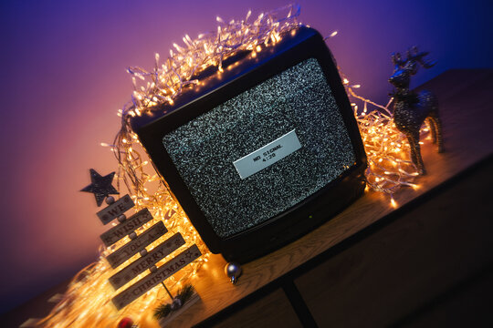 Vintage CRT television, no signal static, glowing lights and festive holiday decorations