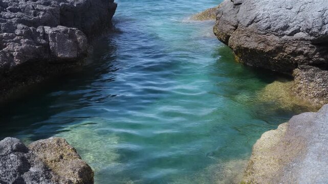 岩の間に溜まった透明な水の揺れ シームレスループ動画背景 16:9 4K