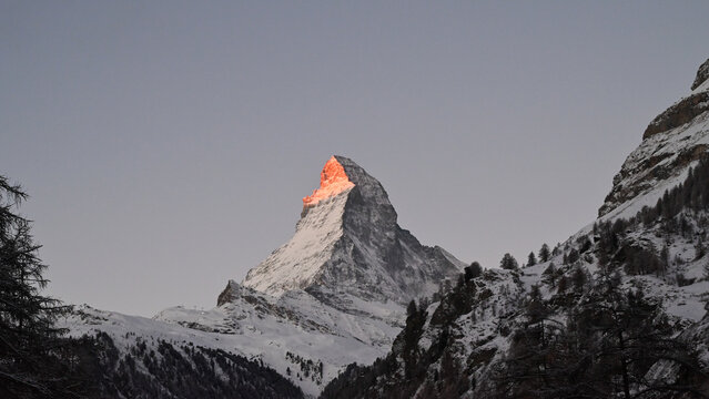 Matterhorn mountain peak glowing red at sunrise in winter Zermatt Switzerland