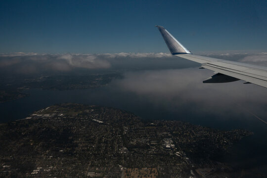 Aerial view of a coastal city and bay from an airplane window during flight