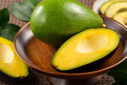 Fresh avocado with sliced and diced pieces over woven bamboo background