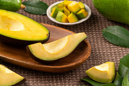 Fresh avocado with sliced and diced pieces over woven bamboo background