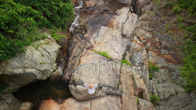 Woman Resting on Rocks at Na Muang Waterfall 2 on Koh Samui