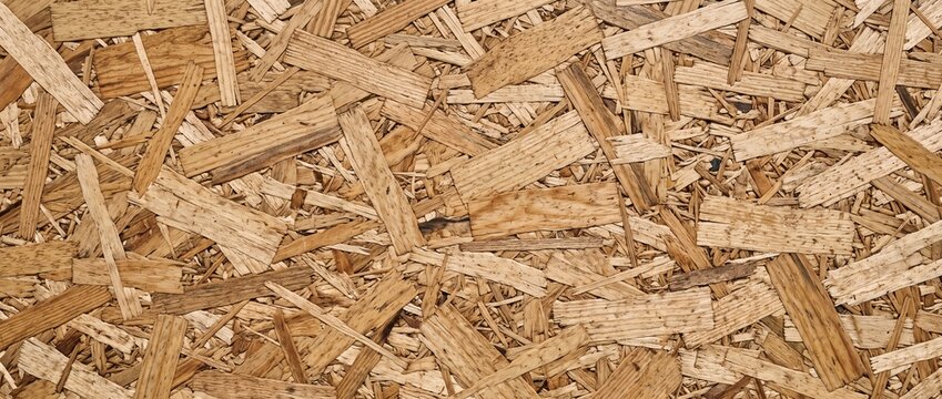 Oriented strand board wood chip panel texture. Close up of pressed wood flakes and resin binder. Construction material background