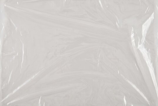 Plastic wrap cling film texture. Creased transparent food storage foil background. Shiny polyethylene sheet
