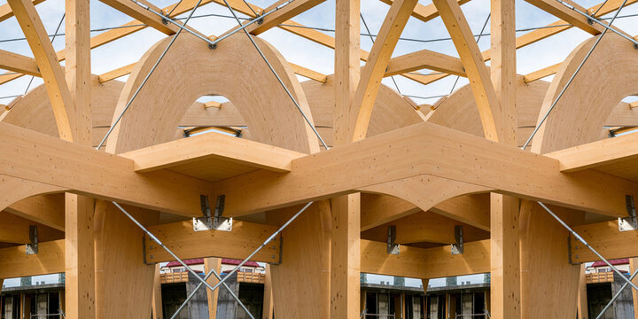 Detail of a modern wooden architecture in glued laminated timber on a blue cloudy sky