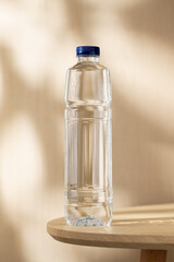 Clear bottled drinking water on a wooden table, illuminated by warm natural light and soft shadows, creating a clean setting for hydration, wellness, and everyday lifestyle concepts. © MINIMAL GIRL