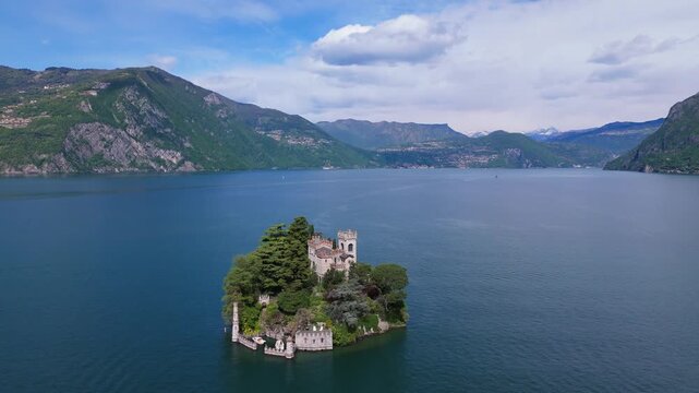 A stunning aerial shot of the private castle on Isola di Loreto, surrounded by the turquoise waters of Lake Iseo and the Italian Alps