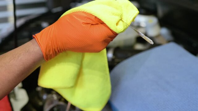 Checking Engine Oil Level with Dipstick and Wiping It Clean. Car Maintenance