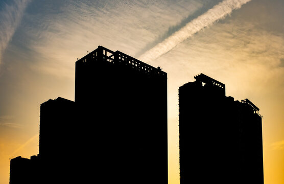 a silhouette of skyscrapers against a sunset sky
