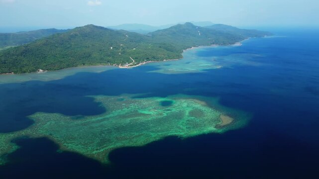 High aerial landscape from the Cagraray View Deck showing deep-blue tropical waters between Cagraray, Liguan and Cawayan Islands under clear sunny skies.