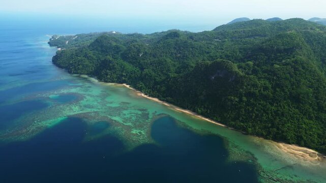Elevated drone perspective over Cagraray Pass and its roadside guardrail, capturing the dramatic transition from the viewpoint to blue coastal waters and distant Liguan and Cawayan Islands.
