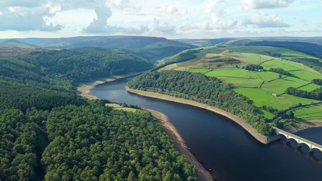 Aerial view of Coach and Horses Rock Formation and Ladybower Reservoir surrounded landscapes, woods, bridges . Drone POV exploration of Peak District National Park in United Kingdom.