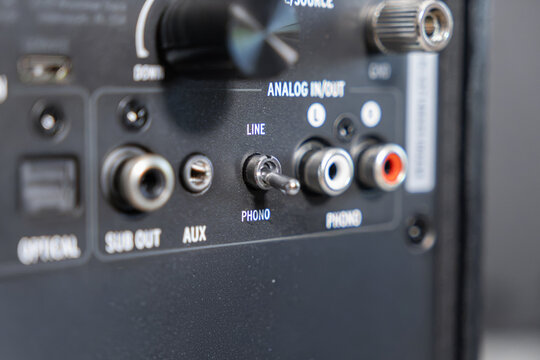 A close up view of the back panel on an audio amplifier, featuring a phono line switch and RCA input connectors to demonstrate professional sound system equipment and connectivity