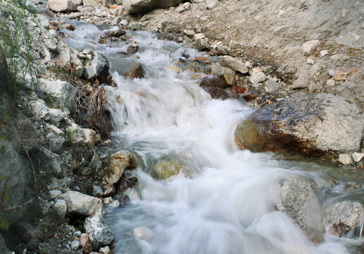 View of a fast-flowing mountain stream cascading over rocks and stones along the K2 trek in Hushe, Pakistan.