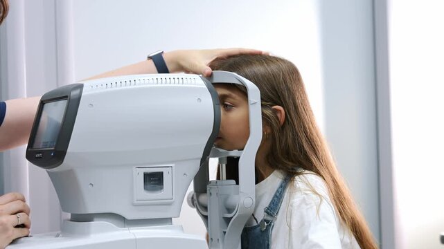 Woman receives an eye test with an autorefractor device in a well-lit optometry clinic, showcasing modern medical equipment and a professional environment