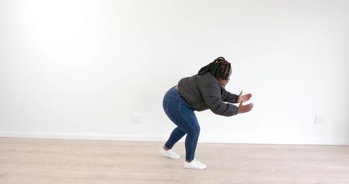 Stretching in bright room, woman in casual outfit focusing on flexibility