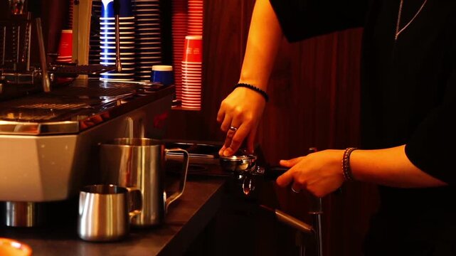 The barista tamps down the coffee puck
