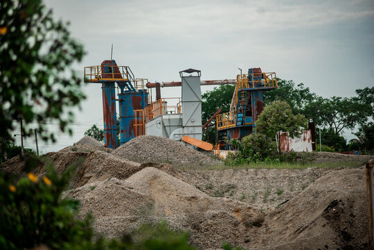 View of industrial stone crushing machinery and piles of gravel at a mining site in Jos North, Plateau, Nigeria.