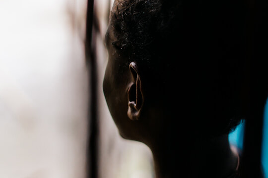 View of a person in profile with soft lighting and dark shadows in Southwest Papua, Indonesia.