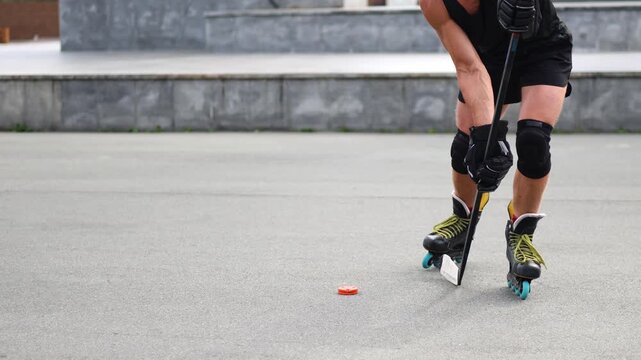 Maintaining hockey skills during the summer. The grace of a middle-aged man's legs gliding effortlessly on an asphalt rink while he practices roller skating moves, embodying passion for the sport.