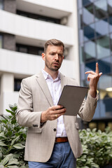 Confident businessman using digital tablet in front of modern office building © Novak