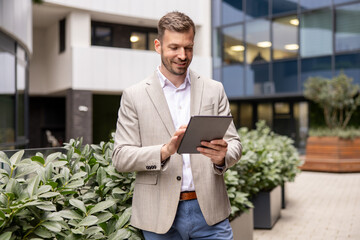 Confident businessman using digital tablet in front of modern office building © Novak