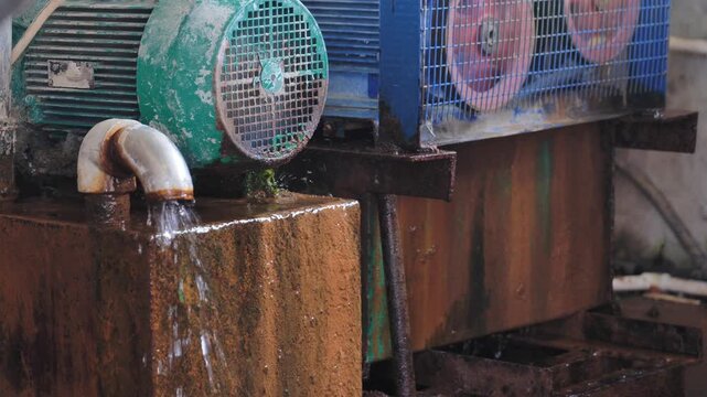 Old electric motor and industrial pump working at a weathered cow farm