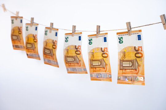 Euro fifty bills drying on a rope with clothespins, concept of illicit money washing, corruption, and fraud