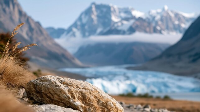 A breathtaking view of serene mountains and a beautiful glacier in the distance, highlighting the natural beauty and tranquility of a pristine wilderness landscape.