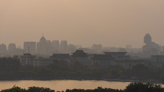 View of the historic architecture of the Forbidden City and modern skyline of Beijing under a hazy sky in Beijing, Beijing, China.
