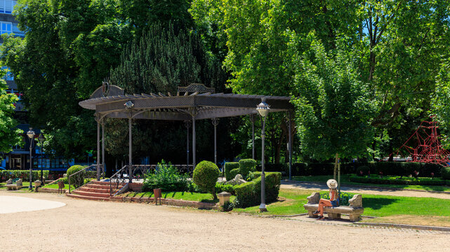 Woman sitting on bench near bandstand in park at Ciudad Real Spain