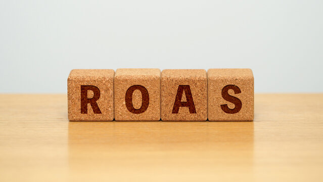 ROAS on four cork wooden blocks - return on ad spend concept