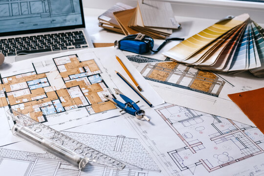 architect Eco retrofit planning with blueprints, material swatches and finish samples, sustainable renovation budget and healthy material selection concept for honest architectural design.