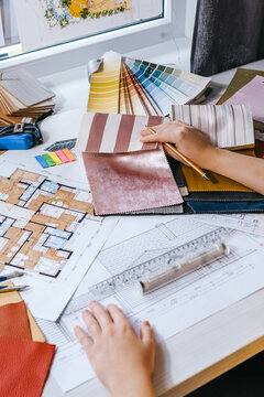 architect Eco retrofit planning with blueprints, material swatches and finish samples, sustainable renovation budget and healthy material selection concept for honest architectural design.