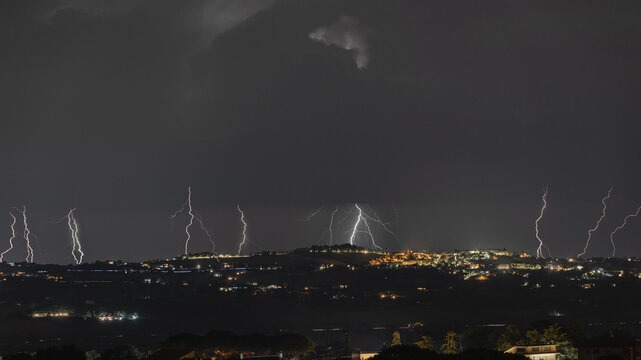 View of multiple lightning strikes illuminating the night sky over Morrovalle, Marche, Italy.