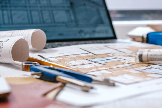 architect Eco retrofit planning with blueprints, material swatches and finish samples, sustainable renovation budget and healthy material selection concept for honest architectural design.