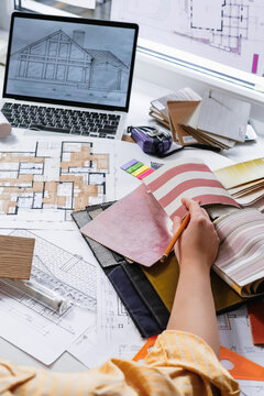 architect Eco retrofit planning with blueprints, material swatches and finish samples, sustainable renovation budget and healthy material selection concept for honest architectural design.