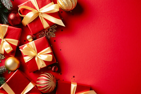 Christmas gift boxes and holiday decorations on red background