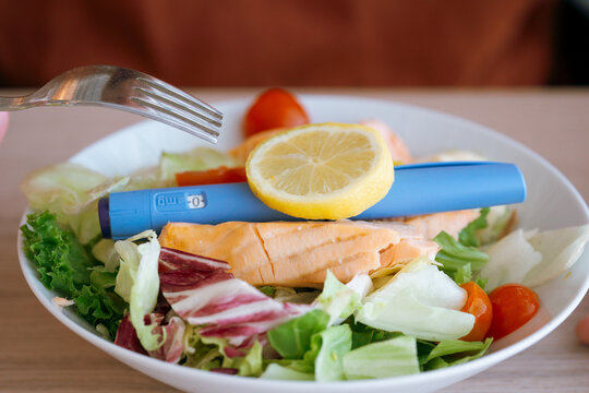 ozempic semaglutide injection pen salmon salad healthy meal weight loss diabetes medication lemon fork plate concept of healthy lifestyle nutrition medical treatment