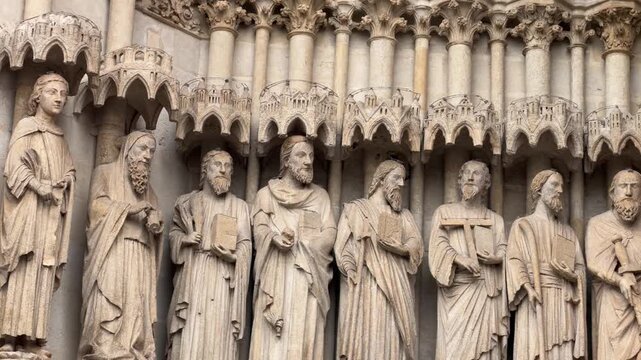 Stone statues of religious figures line the ornate facade of Amiens Cathedral in France