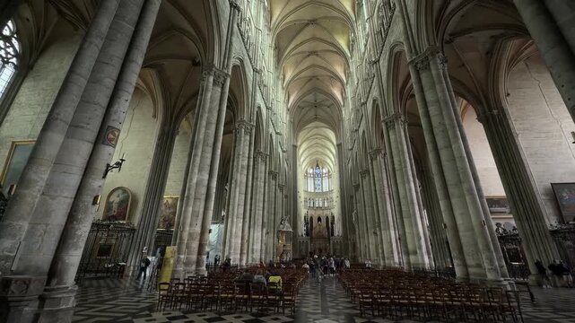 Visitors explore the grand nave of Amiens Cathedral with soaring Gothic arches