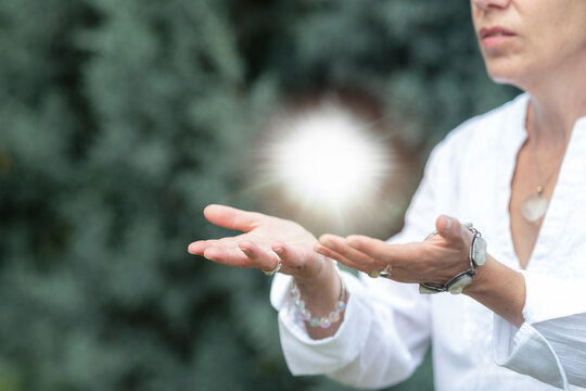 Mindfulness practice receiving healing energy with open hands and glowing light orb, spiritual wellness