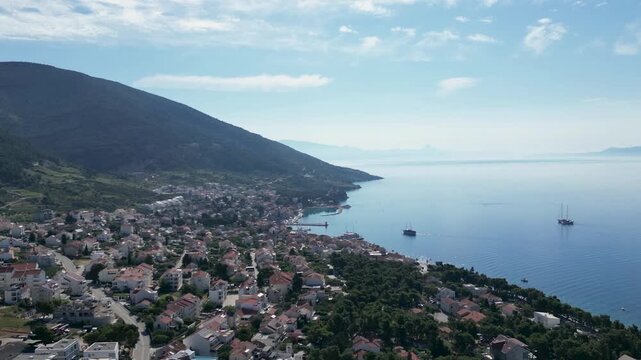 Aerial timelapse over a Croatian town on Brač Island, showing the harbour receiving and dispatching boats against a beautiful Adriatic coastal setting.