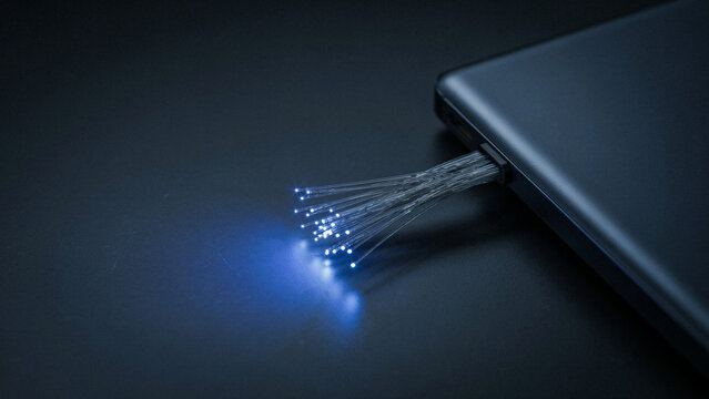 Close up of glowing fiber optic cables connected to a modern smartphone device with data transfer modern technology glowing lights tech connection optical cable