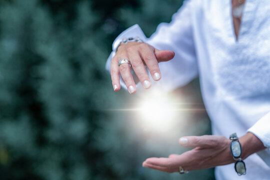 Mindfulness practice shaping a glowing healing energy field with the hands, spiritual meditation