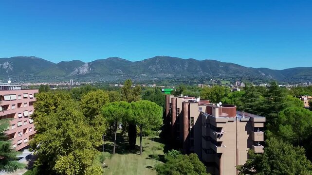 High-angle phone footage of Terni, Umbria, Italy, showing city rooftops surrounded by green hills, trees and the beautiful countryside landscape of central Italy.