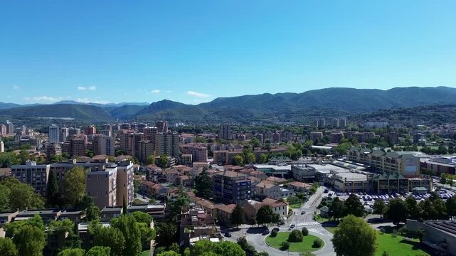Drone footage overlooking Terni in Umbria, Italy, with residential rooftops, lush green hills and a scenic countryside landscape surrounding the city.