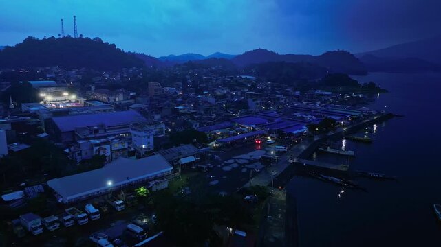 Cinematic aerial view of Buhi town and Lake Buhi during blue hour in Camarines Sur, Philippines. The footage features the urban and lakeside areas around San Benito, San Pascual and Santa Cruz, with M